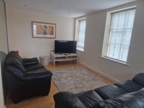 a living room with a couch and a television at Spacious 1bed Apt in Leeds City Centre in Leeds