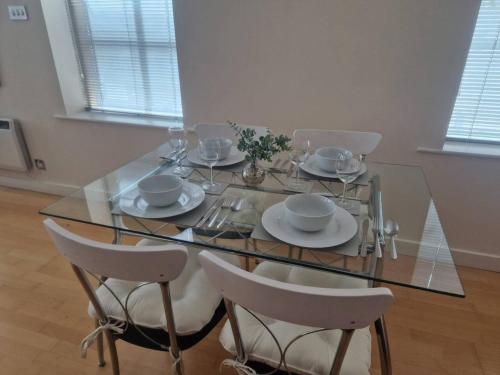 a glass table with chairs and plates on it at Spacious 1bed Apt in Leeds City Centre in Leeds