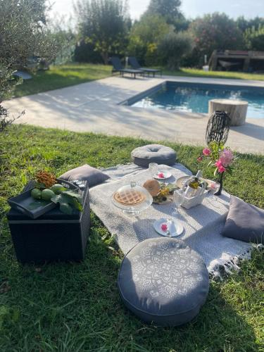 a picnic table in the grass next to a pool at Nakupenda Relais in Latina