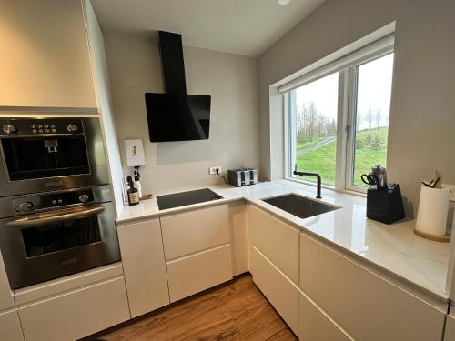 a kitchen with a sink and a stove at Urriðafoss Waterfall Villa in Selfoss