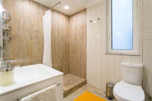 uma casa de banho com um WC branco e um lavatório. em Principe Real cool and artistic 3 bedrooms flat! em Lisboa