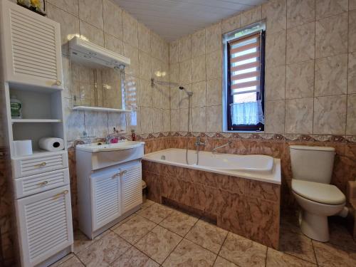 een badkamer met een bad, een toilet en een wastafel bij Apartament Matejki in Sierpc