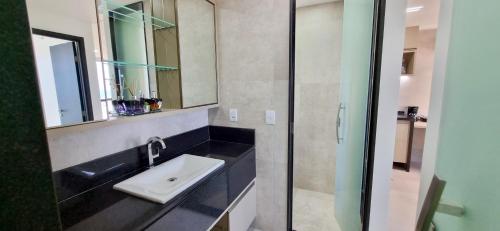 La salle de bains est pourvue d'un lavabo et d'un miroir. dans l'établissement Flat a beira mar, à Récife