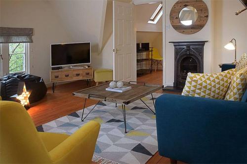 a living room with a tv and a couch and a table at Unique 3 b'room house + free parking /city centre in Nottingham