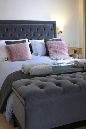 a bedroom with a large bed with pink pillows at Unique 3 b'room house + free parking /city centre in Nottingham