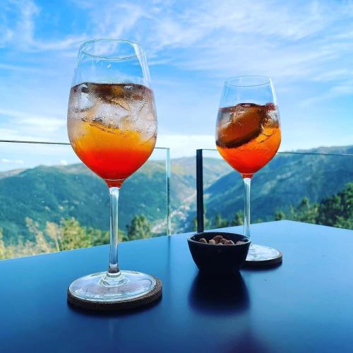 two wine glasses sitting on a table with a view at Casa de São Lourenço - Burel Panorama Hotel - member of Design Hotels in Manteigas