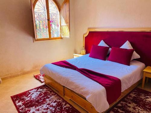 ein Schlafzimmer mit einem großen Bett mit roten Kissen in der Unterkunft Villa Korima in Marrakesch