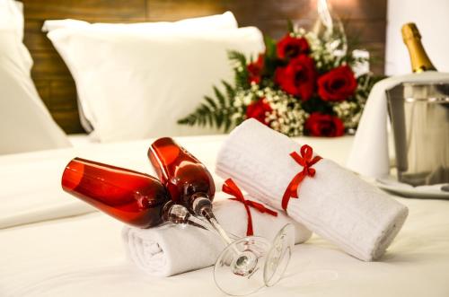 a pair of wine glasses sitting on top of a bed at Hotel Cercano in Gramado