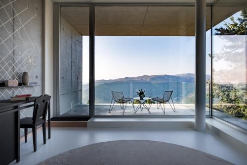 a kitchen with a table and chairs and a large window at Casa de São Lourenço - Burel Panorama Hotel - member of Design Hotels in Manteigas