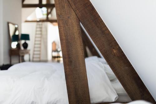 a wooden frame of a bed with white pillows at Edville Home in Ghent