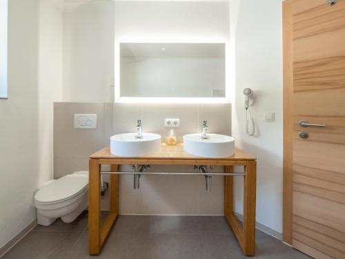 a bathroom with two sinks and a toilet at Falwesuna Apartments in Neustift im Stubaital