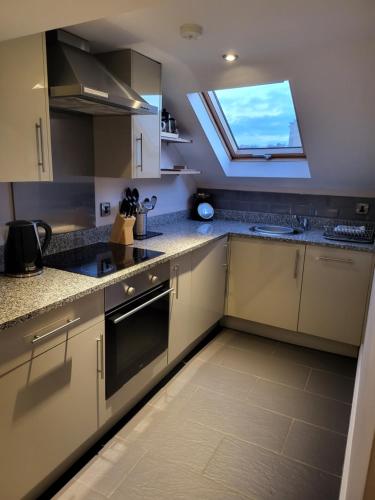 a large kitchen with a skylight in the ceiling at Harrogate Lifestyle Luxury Serviced ApartHotel in Harrogate
