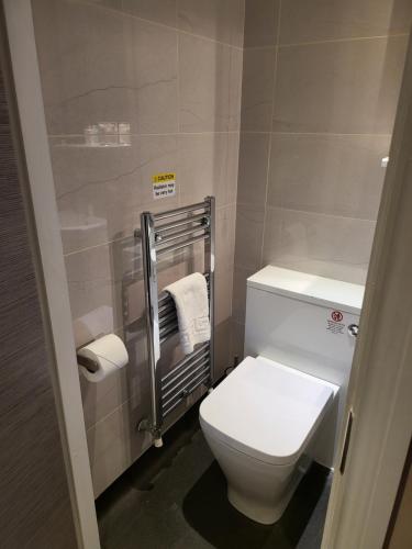 a small bathroom with a toilet and a towel rack at Harrogate Lifestyle Luxury Serviced ApartHotel in Harrogate