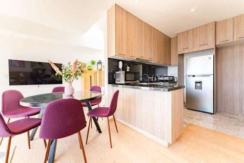 a kitchen with purple chairs and a table in a kitchen at NEW La Roma Penthouse 100m2 Terrace Pool and Gym in Mexico City