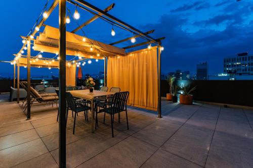 a patio with a table and chairs and lights at NEW La Roma Penthouse 100m2 Terrace Pool and Gym in Mexico City