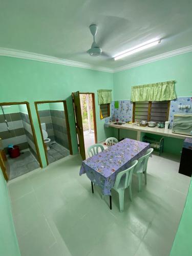 ein Esszimmer mit einem lila Tisch und Stühlen in der Unterkunft Rumah Comel in Kampung Degong