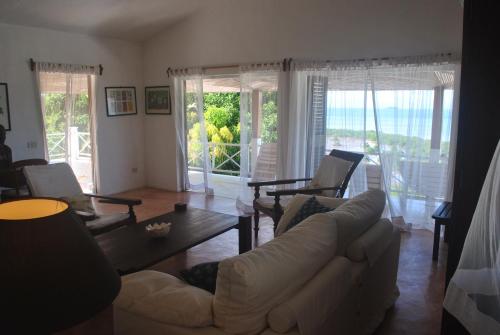 a living room with a couch and a table at Villa Palissandre in Nosy Be