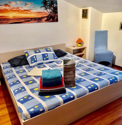 a bedroom with a bed with a blue and white comforter at Apartman Luna Punat in Punat