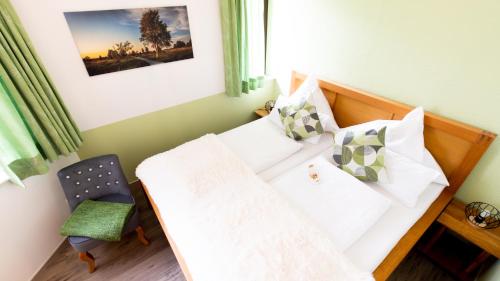 a small bedroom with a bed and a chair at Alt Monjoie in Roetgen