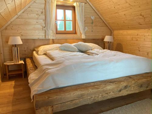 una camera con un grande letto in una baita di tronchi di Ferienhaus Zwickelreith a Göstling an der Ybbs