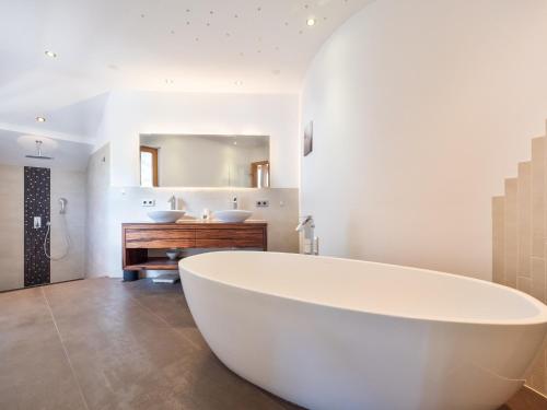 y baño con lavabo y bañera blanca grande. en Falwesuna Apartments, en Neustift im Stubaital