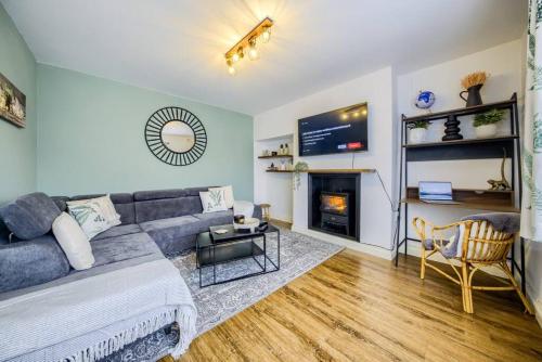 a living room with a couch and a fireplace at 4 Bedroom House in Coventry, Sleeps 10, Unlimited Wi-Fi, with Fireplace, Free Parking - 53QMC in Coventry