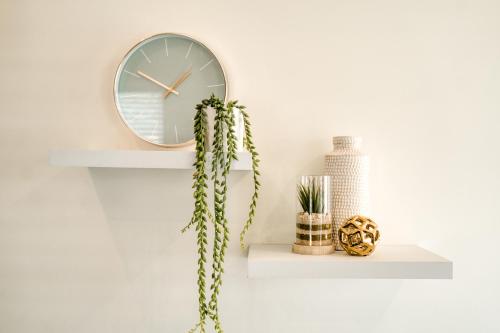 a shelf with a clock and a cactus at Hampton Collection - Contemporary 3 Sleeper Apartment with Pool in Durban