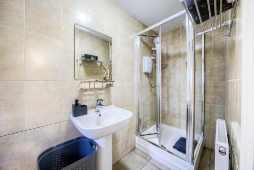 a bathroom with a sink and a shower at 4 Bedroom House in Coventry, Sleeps 10, Unlimited Wi-Fi, with Fireplace, Free Parking - 53QMC in Coventry