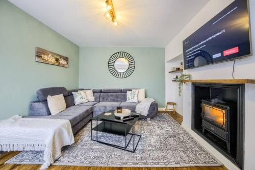 a living room with a couch and a fireplace at 4 Bedroom House in Coventry, Sleeps 10, Unlimited Wi-Fi, with Fireplace, Free Parking - 53QMC in Coventry