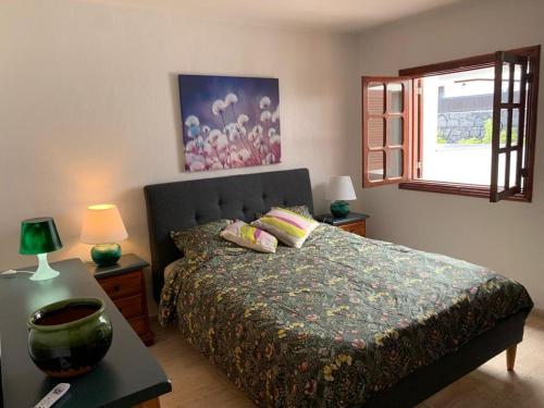 a bedroom with a bed and a table and a window at One bedroom bungalow Playa Bastian Costa Teguise in Costa Teguise