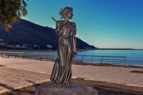 uma estátua de uma mulher em pé numa rocha perto da água em Casa Franiti - Sul Mare em Sapri