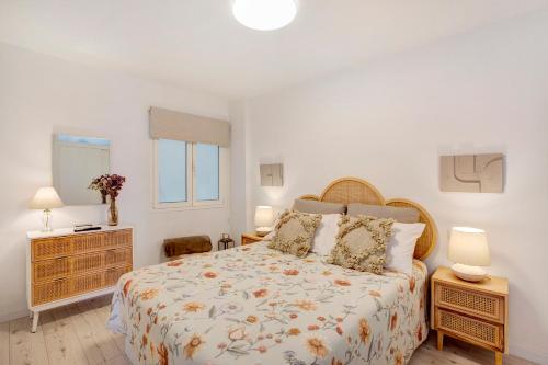 ein Schlafzimmer mit einem Bett, zwei Lampen und einem Fenster in der Unterkunft Salitre Suites Tamara in Tacoronte