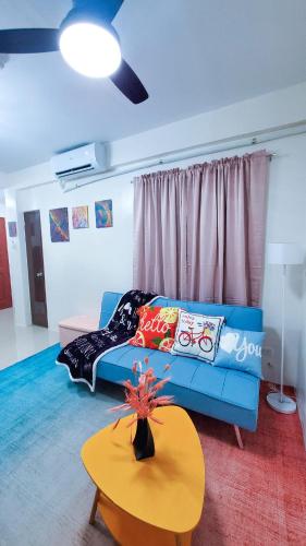 a living room with a blue couch and a table at la maison `a Almande Drive in Talisay