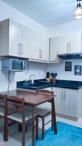 a kitchen with a wooden table and a sink at homeist south almond drive in Talisay