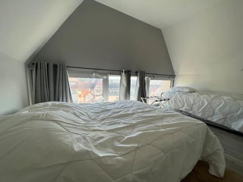 un letto bianco in una stanza con una finestra di Résidence Ascot 7 pers a Le Touquet-Paris-Plage