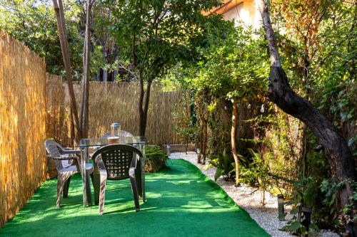 a table and chairs on a green lawn at Bord de mer- Studio avec jardin in Roquebrune-Cap-Martin
