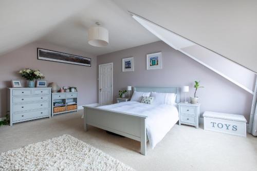 a bedroom with a white bed and white furniture at Stunning Sea View Home 2 Minutes Walk to the Beach in Bournemouth