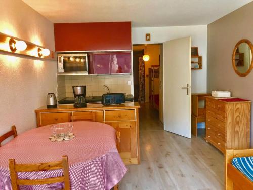 une cuisine avec une table recouverte d'une nappe rose dans l'établissement Studio Cabine avec Balcon Proche Centre et Pistes, Parking et Navette Gratuite - FR-1-515-98, à Villard-de-Lans