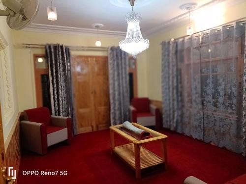 a living room with chairs and a table and a chandelier at Moonshine Homestay Kashmir in Srinagar