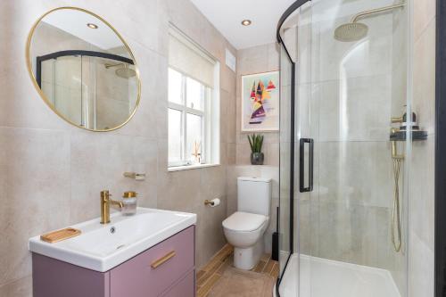 a bathroom with a sink toilet and a mirror at Fashionable Chic Townhouse in D4 in Dublin