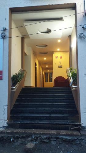 a hallway with stairs in a building with plants at Le Grace Bye Pass in Madurai