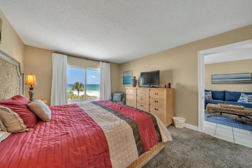 a bedroom with a bed and a television and a window at Destin on the Gulf 403 - This is a beautiful beach front condo with a great view of the gulf in Destin