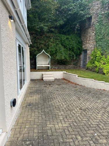 a brick patio with a bench next to a building at Cameron Coach House Modern Property in Murrayfield Edinburgh in Edinburgh
