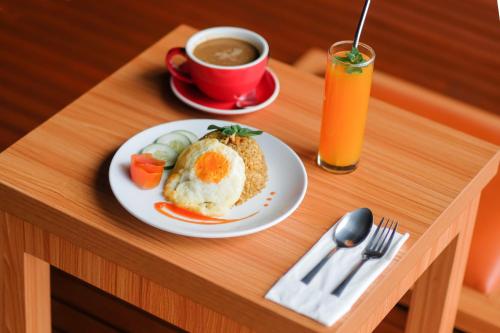 a table with a plate of food and a cup of coffee at Kema Merbabu powered by Cocotel 