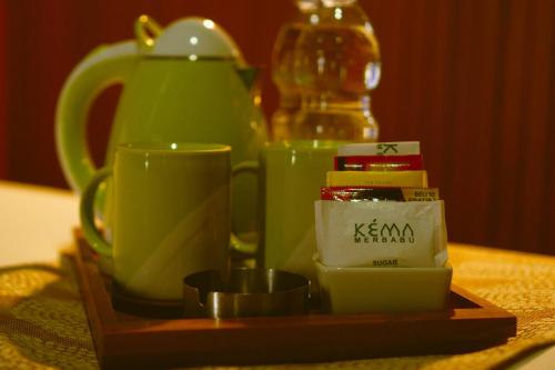 a tray with green cups and tea pots on a table at Kema Merbabu powered by Cocotel in Kembang