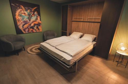 een slaapkamer met een bed en een schilderij aan de muur bij Vakantiewoning Het Kwartelnest Mettekoven (Heers) in Heers