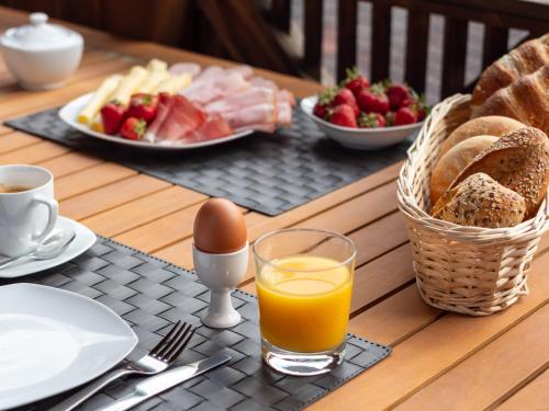 a table with a breakfast of eggs bread and fruit at Falwesuna Apartments in Neustift im Stubaital