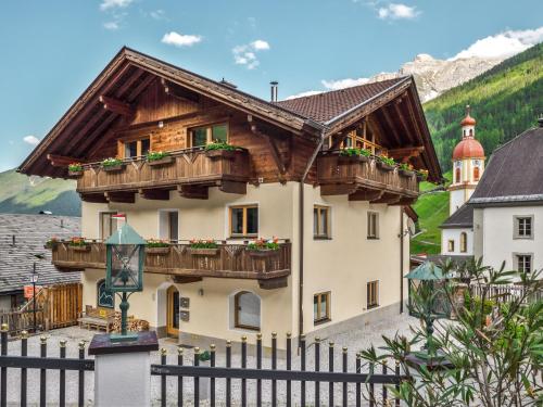a house with wooden balconies and a fence at Falwesuna Apartments in Neustift im Stubaital