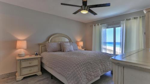 a bedroom with a bed with a ceiling fan and a window at Destin on the Gulf 604 - Updated Gulf Front sixth floor condo in Destin