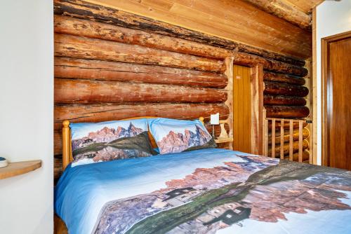 a bedroom with a bed in a log cabin at Baita Valmesta in Fiera di Primiero